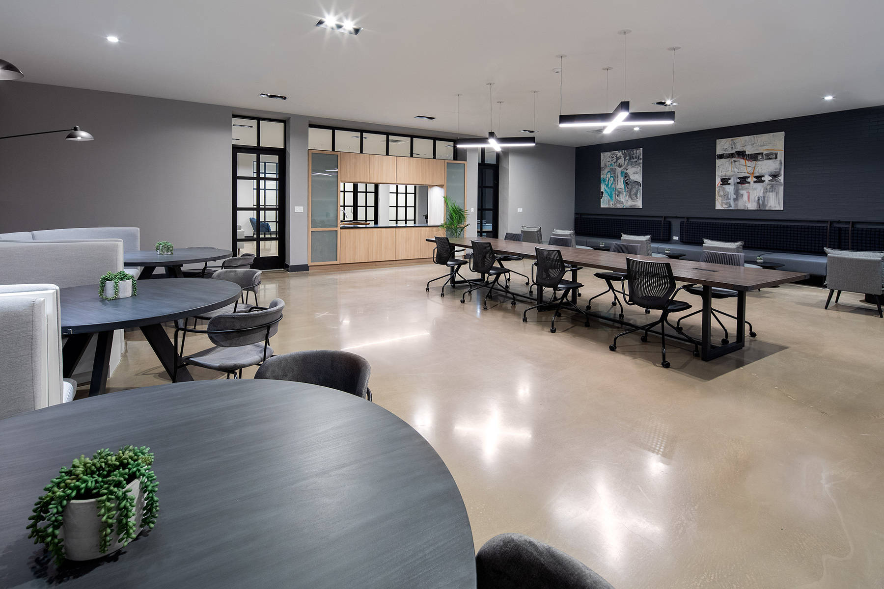 Coworking space with large conference size table with chairs and additional side tables and seating